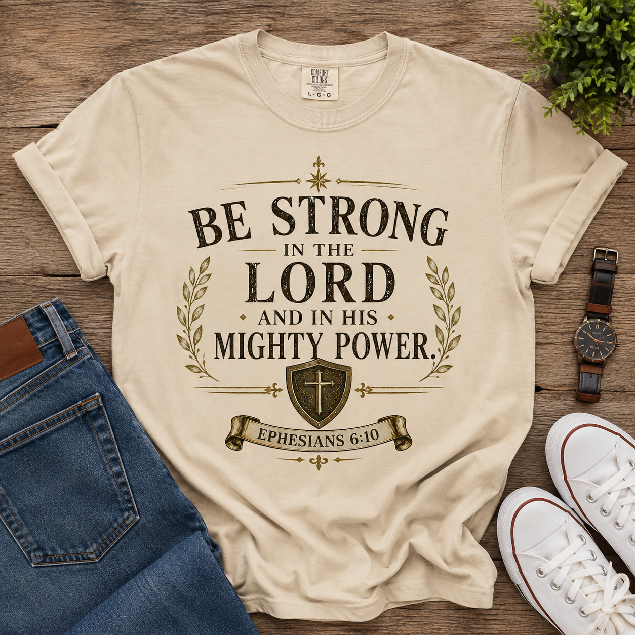 Be Strong in the Lord Ephesians 6:10 unisex Christian t-shirt in beige with vintage brown and gold shield and cross design.