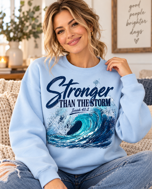 Light blue Stronger Than the Storm Christian sweatshirt featuring an ocean wave design and Isaiah 43:2 from the Journey Wear collection.