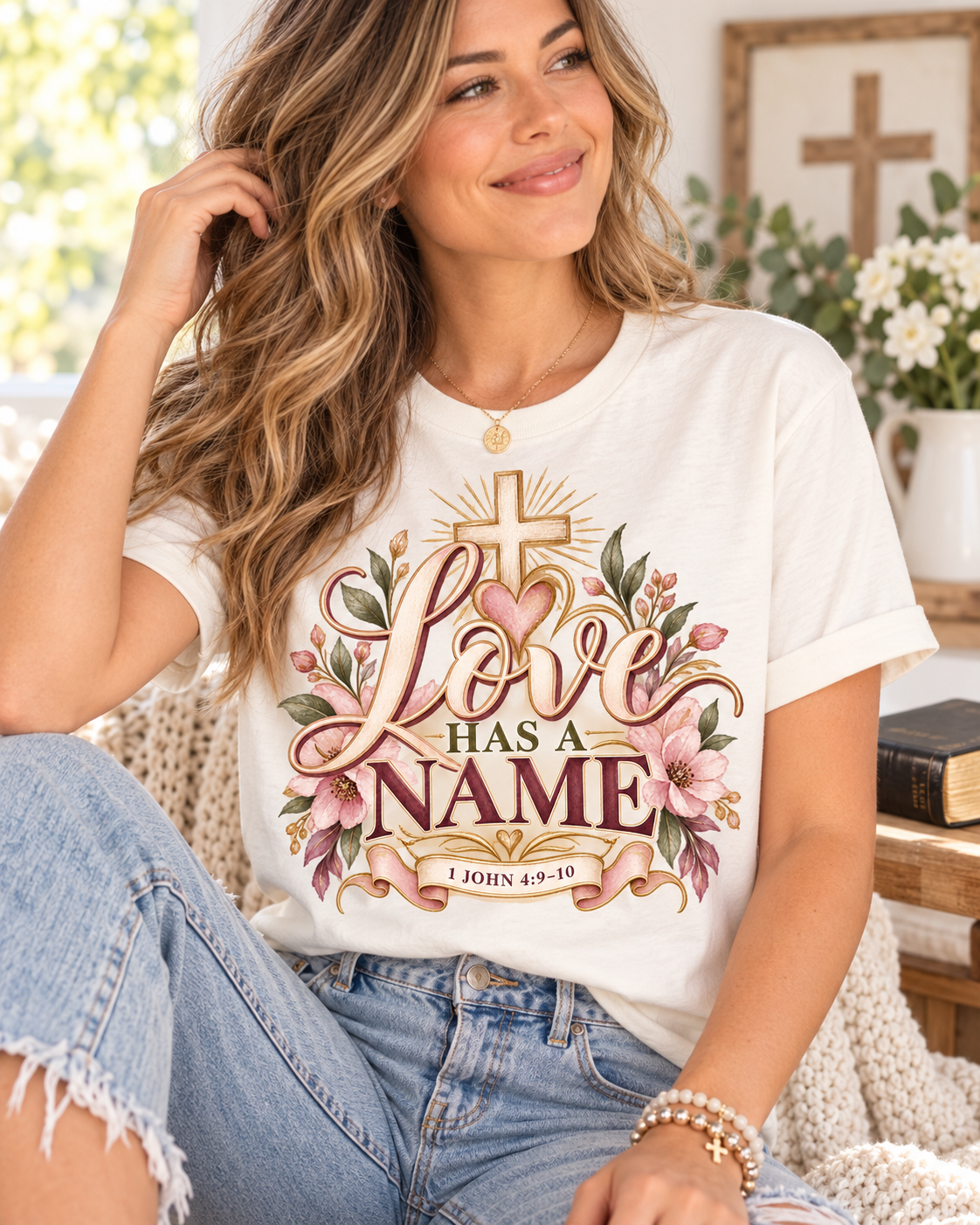 Love Has a Name Christian T-Shirt featuring a cross, floral design and 1 John 4:9–10 from the Journey Wear collection.