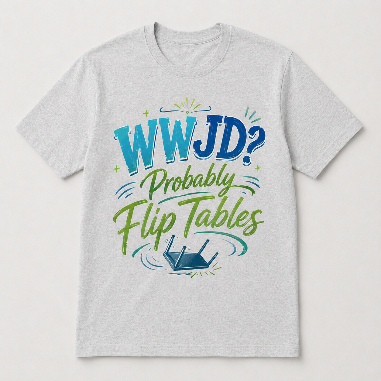 A light heather gray crewneck t-shirt featuring a colorful graphic on the front with the text 'WWJD? Probably Flip Tables' in blue and green lettering, accompanied by a small blue router illustration.